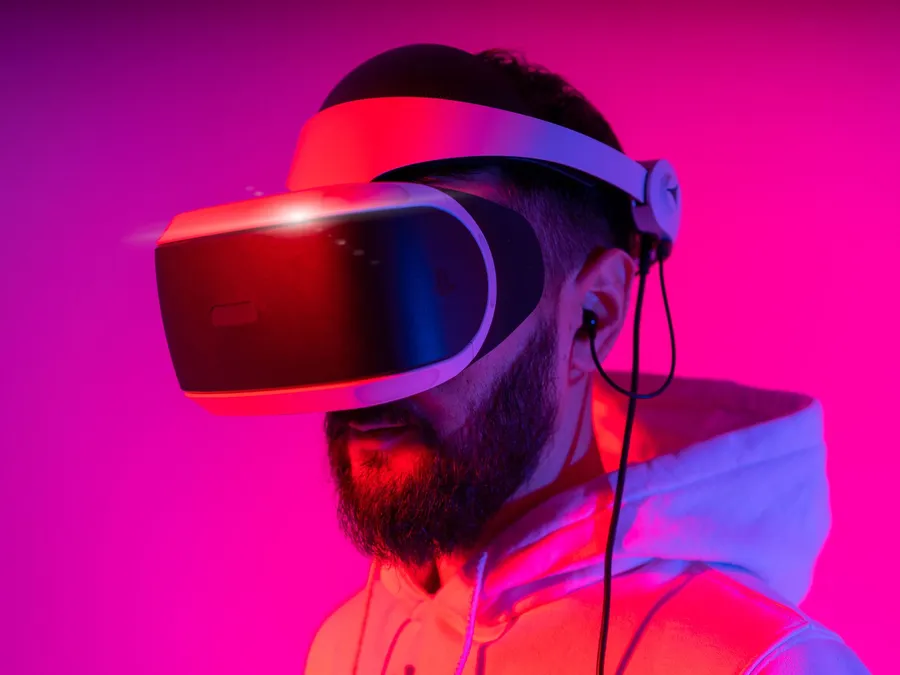 Man wearing a VR headset under vivid pink and red lighting